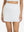 Front lower body shot of model wearing white high waist built-in short a-line golf skirt with 5 pockets