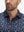 Front view from nose to chest of model wearing the navy sailboat 4 way stretch print collared polo shirt, showcasing the upper fit