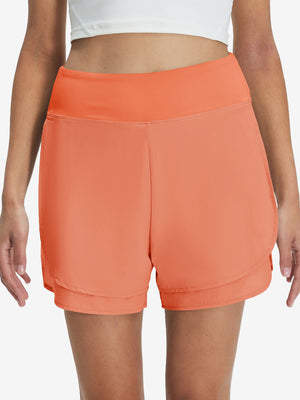 Front lower body shot of model wearing peach pink women's gym golf shorts with liner pocket