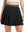 Front lower body shot of model wearing black women's moisture-wicking athletic tennis skirts