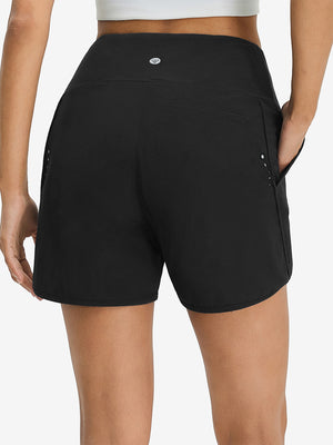 Back lower body shot of model wearing black women's high waist 2 in 1 quick dry shorts with 7 pockets