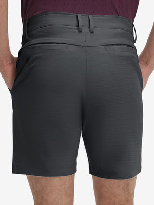 Back lower body shot of model wearing iron grey flat front hybrid golf shorts