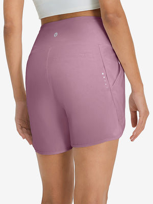 Back lower body shot of model wearing lavender pink women's high waist 2 in 1 quick dry shorts with 7 pockets