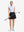 Front full body shot of model with golf gear wearing black women's moisture-wicking athletic tennis skirts