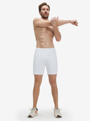 Front full body shot of model exercising in white 4 way stretch breathable workout athletic shorts