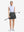 Front full body shot of model with golf gear wearing dark grey women's moisture-wicking athletic tennis skirts