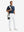 Full-body front: model in white stretch quick dry casual golf pants with 4 pocketscarrying golf bag on shoulder.