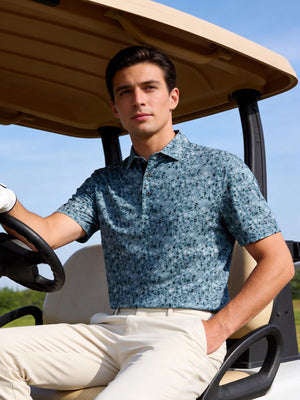 Outdoor shot of a model sitting on a golf cart, wearing the camo fragments performance quick dry print golf polos with a relaxed fit