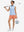 Front full body shot of model with golf gear wearing peach pink women's gym golf shorts with liner pocket