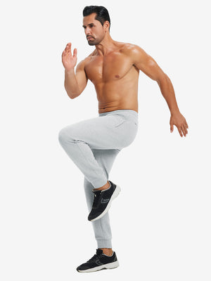 Back lower body view showing light grey heather soft sweatpants with 4 zipper pockets