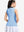 Back upper body shot of model wearing light blue women's collared v neck quick dry tank tops