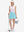 Front full body shot of model with golf gear wearing lake green women's stretch a-line golf skort with 7 pockets