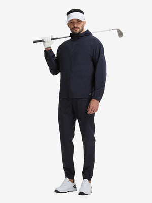 Full body shot of model playing golf in navy waterproof lightweight rain jacket with hood