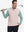 Model holding golf club, wearing print collar quarter zip golf vest in light pink, upper body view.