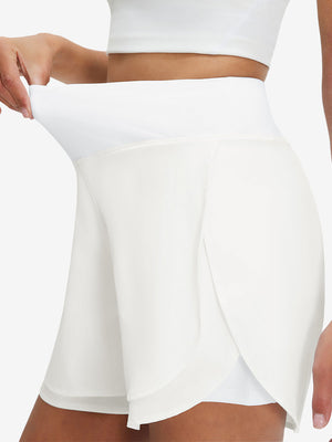 Detail view of elastic waistband on white women's gym golf shorts with liner pocket