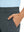 Close-up detail of one hand resting in pocket, showing relaxed fit of the dark grey quick dry pants.