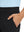 Close-up detail of one hand resting in pocket, showing relaxed fit of the black quick dry pants.
