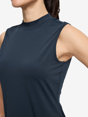 Detail view of armhole on navy blue women's moisture-wicking mock neck sleeveless golf tops