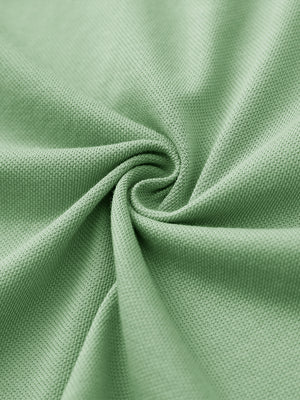 Fabric close-up of light green cotton blend pique plain shirt, breathable pique fabric texture.