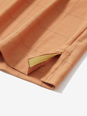 Detail view of hem on orange adobe reflective performance reflective checked collar golf shirt