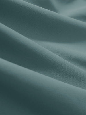 Close-up texture of dusty blue women's athletic quarter zip tank tops fabric showing detailed athletic material and weave.