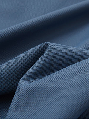 Close-up texture of slate blue waffle texture 1/4 zip pullover fabric showing detailed waffle knit material and weave.