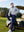 Model seated in a golf cart, wearing stretch plain everyday pants in navy with relaxed fit