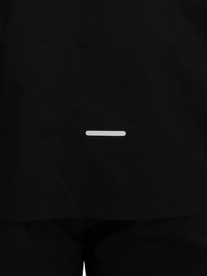 Back hem reflective detail of black waterproof lightweight rain jacket with hood