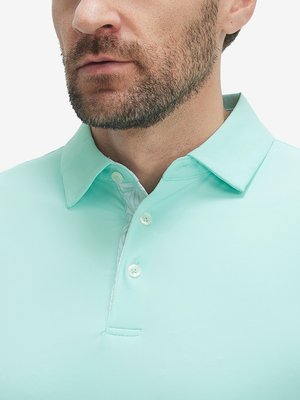 Close-up of a model wearing the aqua blue everyday classic solid polo, focusing on the collar and chest area